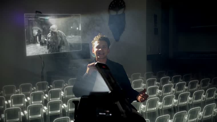 El celular proyectando una pantalla de cine con butacas dibujadas en luz